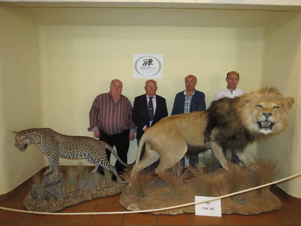 Ramón Medina, Gregorio Medina, Jesús Medina y Gregorio Medina Jr. con un leopardo y un león naturalizados en su taxidermia.